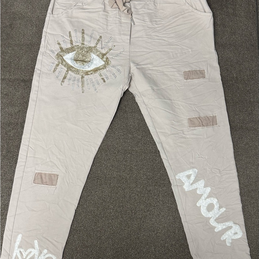 Italian Beige Joggers with Eye and Amour Design. NWT One size fits up to 12